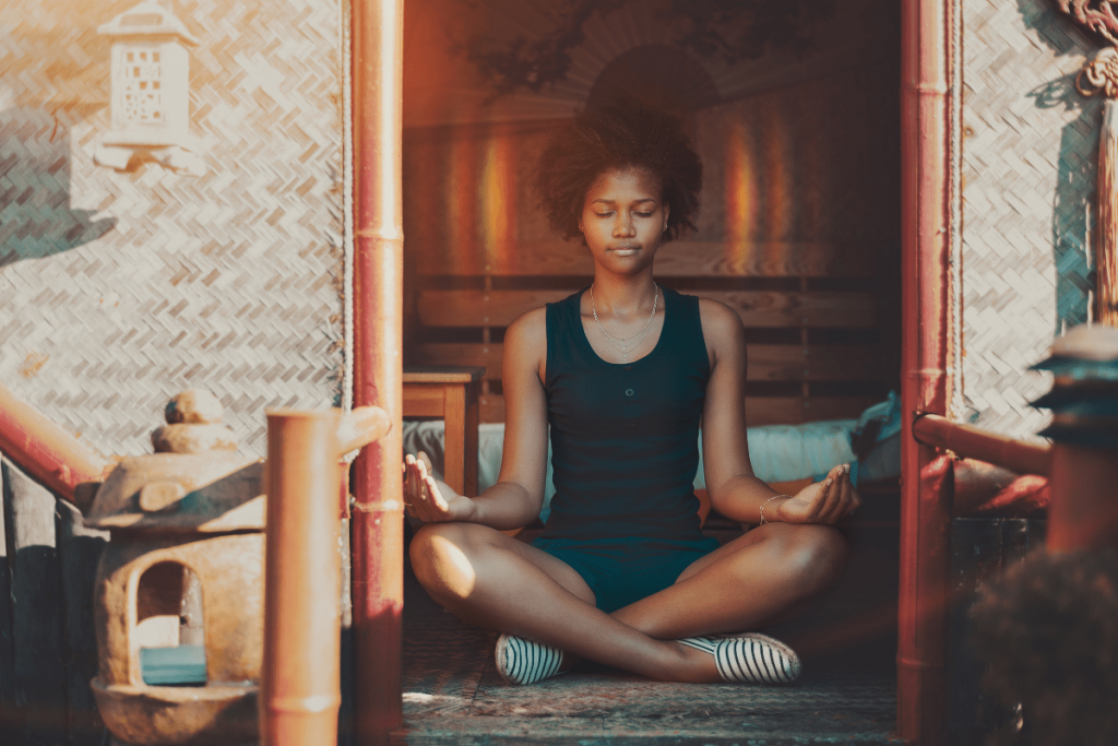 black girl sitting in a meditative pose with eyes closed